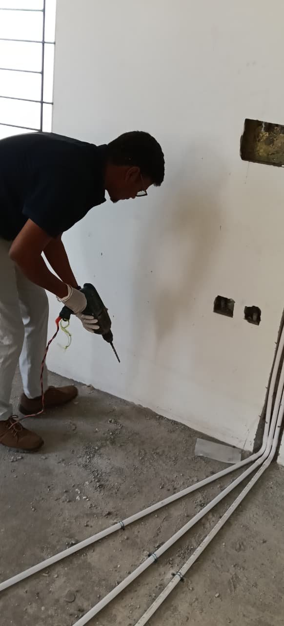 Technician spraying pest treatment along a floor skirting